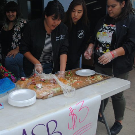 Brianna Molina, 11, quickly removes a large piece of a Titos sandwich to sell.