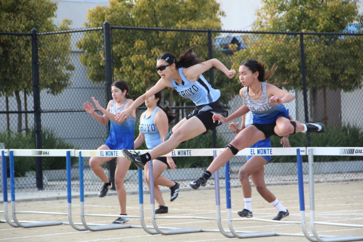 Haley Pham (12) racing her heart out at the first league meet at El Monte High School and hurdling into victory. 