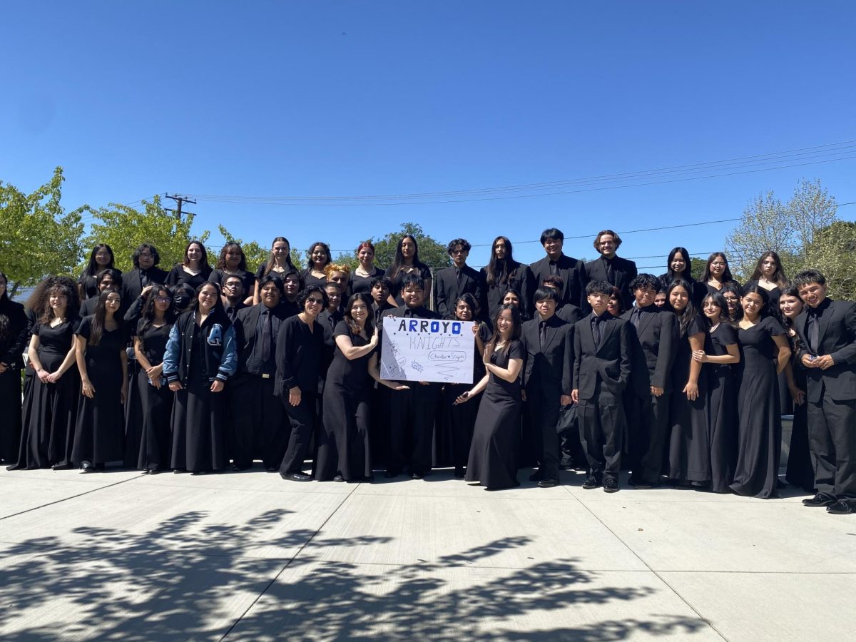 Arroyos Choir members showing there school pride at Norco High School Choral Festival with a poster that was gifted to them.