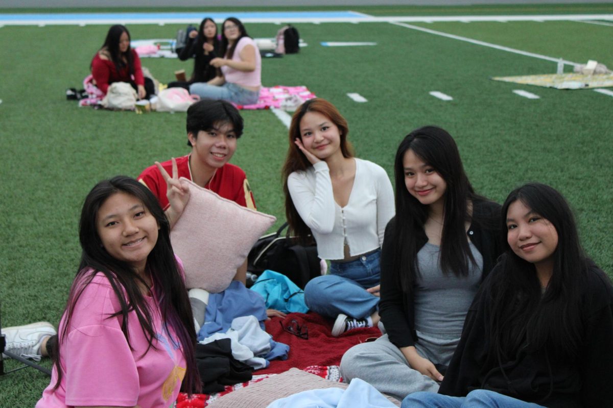Seniors enjoying their time together on the football field with their blankets and pillows.